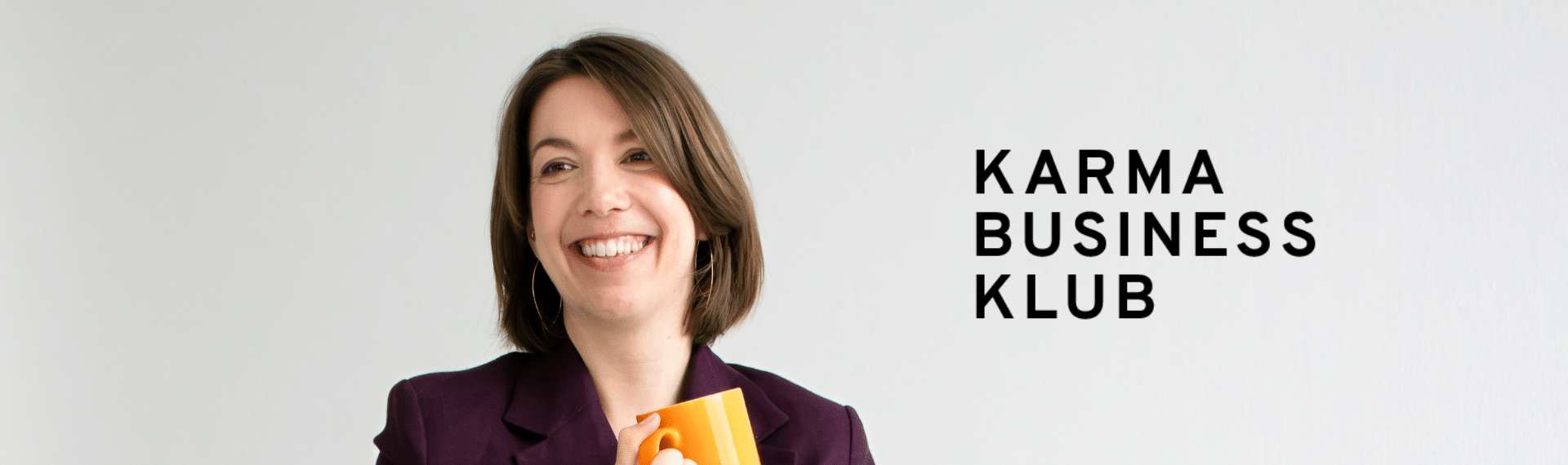 Portrait eine Frau mit kurzen braunen Haaren und einer orangenen Kaffeetasse in der Hand